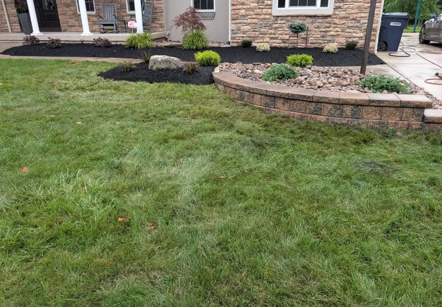 Renovated bed with retaining wall, mulch, plants and sod in Grand Island, NY